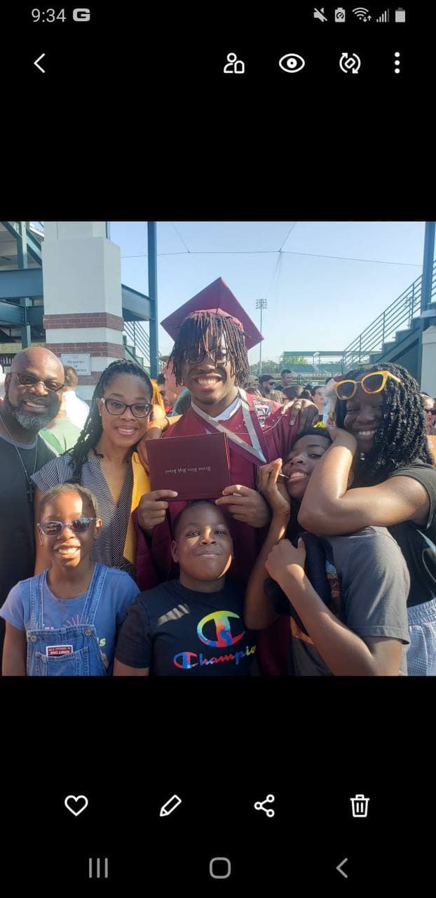 A family celebrating a graduation together in a group photo.